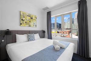 a bedroom with a bed and a large window at Comfort Apartments Melbourne Central in Melbourne +105 photos