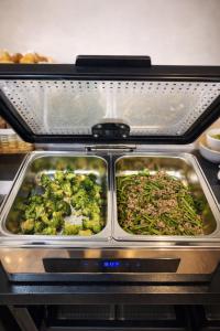 two trays of broccoli and other food in an oven at Kurmon Inn in Omachi