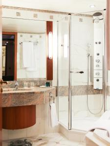La salle de bains est pourvue d'une douche et d'un lavabo. dans l'établissement Le Royal Hotels & Resorts Luxembourg, à Luxembourg