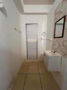 a white bathroom with a sink and a window at Condomínio Boa Ideia apart completo ao lado North Shopping Maracanaú in Maracanaú
