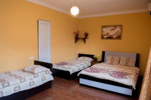 two beds in a room with yellow walls at Hotel Kvareli in Tbilisi City