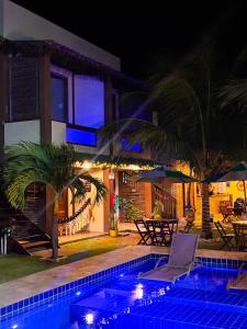 a swimming pool in front of a house at night at Pousada Areias de Flecheiras in Flecheiras