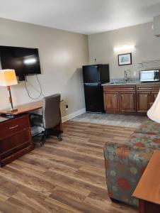 a hotel room with a desk and a kitchen at Gated 1 King BR1 Bath Apt with Full Kitchen 124 in Baton Rouge +10 photos