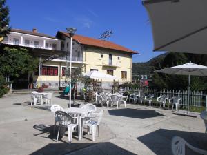a group of white tables and chairs with umbrellas at L'Ostu del Povr-Om in Pinasca 