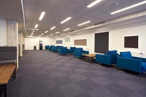 an empty room with blue chairs and a classroom at Living Suites in Nærum
