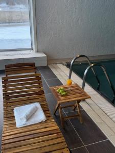 two wooden benches and a table with fruit on it at Oppheim Resort - Pool, Sauna & Lake! in Vossevangen