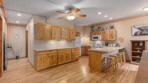 a kitchen with wooden cabinets and a ceiling fan at 2BR Condo by Lake w Deck, Jetted Tub - Raindrop in Pepin