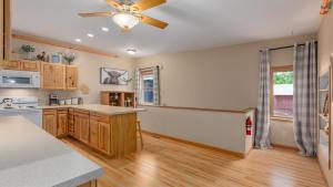 a kitchen with wooden cabinets and a ceiling fan at 3BR Condo Near Lake Pepin w 2 Kitchens - Lantern Condos in Pepin