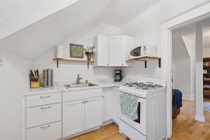 a white kitchen with a stove and a sink at 1BR Apartment Across from Como Lake - Bayberry in Saint Paul