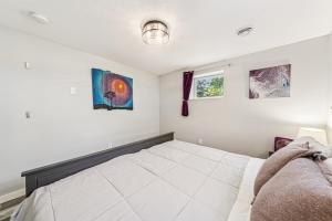 a bedroom with a bed and two paintings on the wall at Cozy 2BR Garden Apartment Near Lake Pepin - Daisy in Pepin