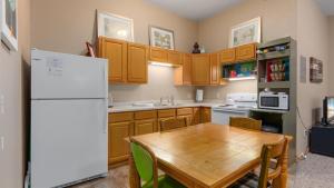 a kitchen with a wooden table and a white refrigerator at Three Connected Quirky Condos By Beach! - Twilight Condo in Pepin