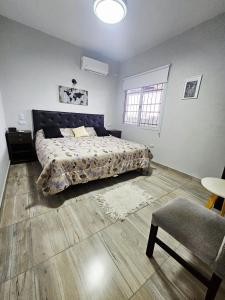 a bedroom with a bed and a table and a chair at Casa Valle Viejo con Cochera Cubierta Gratis in San Fernando del Valle de Catamarca