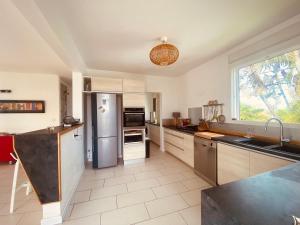 a kitchen with a stainless steel refrigerator and a window at Villa design et piscine Le Gosier in Le Gosier