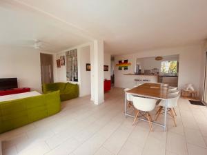 a living room with a table and a couch at Villa design et piscine Le Gosier in Le Gosier
