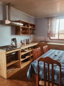 a kitchen with a stove and a table with chairs at cabañas Dany in Concón
