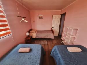 a small room with two beds and a window at cabañas Dany in Concón