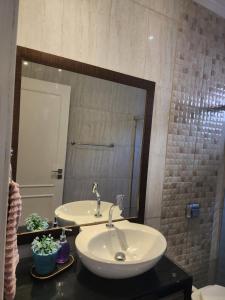 a bathroom with a sink and a large mirror at Loft 150m da praia in Itajaí +4 photos