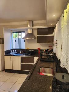 a kitchen with a sink and a counter top at Loft 150m da praia in Itajaí
