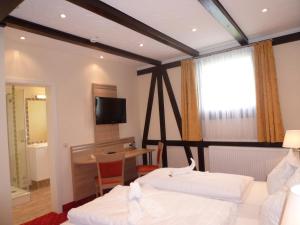 a bedroom with two beds and a desk and a television at Hotel Altes Weinhaus in Neustadt an der Weinstraße +50 photos