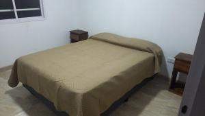a small bed in a room with two tables at Tunquelen II in Colorado River
