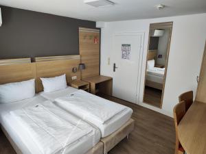 a bedroom with a large white bed and a mirror at Hotel Altes Weinhaus in Neustadt an der Weinstraße