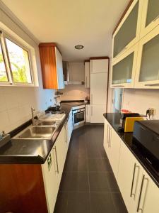a kitchen with white cabinets and a sink and counters at Santos Living Rentals in Funchal