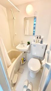 a bathroom with a toilet and a sink and a tub at Good One Awaji Accessia 401 in Osaka