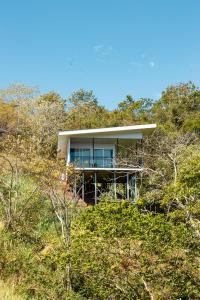 a house on top of a hill with trees at Nosara Hideaway 1 - Mountain View Cabins & BREAKFAST AVAILABLE in Naranjal