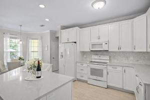 a kitchen with white cabinets and a white counter top at 30A Cottage Near the Beach with Golf Cart in Inlet Beach