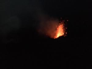 a fire burning in the dark with smoke at A' Riggiola in Stromboli