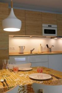 a kitchen with a table with a sink and a microwave at Apartment by Interhome in Cambo-les-Bains