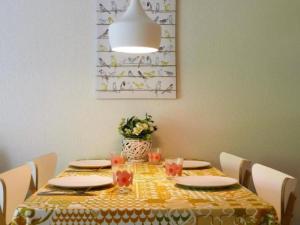 a dining room table with a yellow and white table cloth at Apartment by Interhome in Cambo-les-Bains