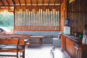 a room with a table and benches in a hut at Pemimpi Sumba in Lambatama