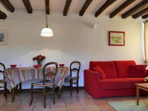 a living room with a table and a red couch at by Interhome in Louhossoa