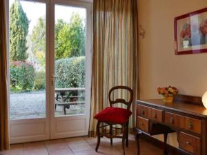 a room with a desk and a chair next to a door at by Interhome in Louhossoa