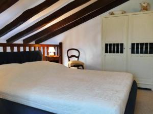 a bedroom with a white bed and a chair at by Interhome in Louhossoa +19 photos