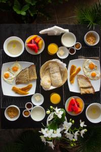 a table topped with plates of breakfast foods and fruit at Nosara Hideaway 2 - BREAKFAST AVAILABLE & Mountain View Cabins in Nicoya