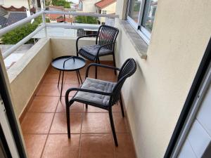 two chairs and a table on a balcony at Sweet home in Entroncamento