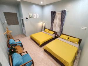 a small room with two beds and a chair at MOJA HOUSE l Homestay Huế in Thôn Dương Xuân Hạ