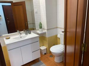 a bathroom with a white sink and a toilet at Sweet home in Entroncamento