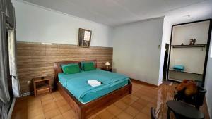a bedroom with a bed with green pillows at The Arya guest house in Gilimanuk