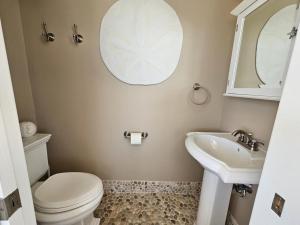 a bathroom with a toilet and a sink at Second Floor Oceanfront Unit in Brant Beach +14 photos