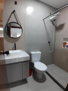 a bathroom with a toilet and a sink and a mirror at Pousada Ferreira TJ - AP 02 in Cesário Lange