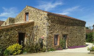 a stone building with a ladder on the side of it at Chambres d'hôtes les Hautes Papinières in Saint-Prouant