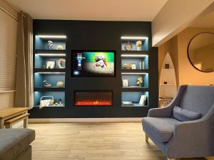 a living room with a tv and a fire place at Mournes Hot Tub Retreat, 4-Star Accommodation in Newcastle