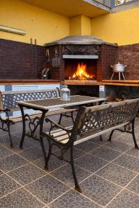 a table and benches in front of a fireplace at Ocean Hill House by Rentery Madeira in Santa Cruz