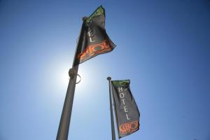 a flag on a pole with a blue sky at Hotel Cajou in De Panne