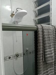 a bathroom with a shower with a shower head and towels at Apto Turismo da Serra in Teresópolis