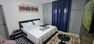 ein Schlafzimmer mit einem Bett und einem Tisch darauf in der Unterkunft O'sena in Cotonou