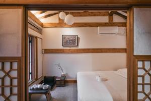 a bedroom with a white bed and a chair at THE CHAE Premium Hanok Stay in Seoul +239 photos